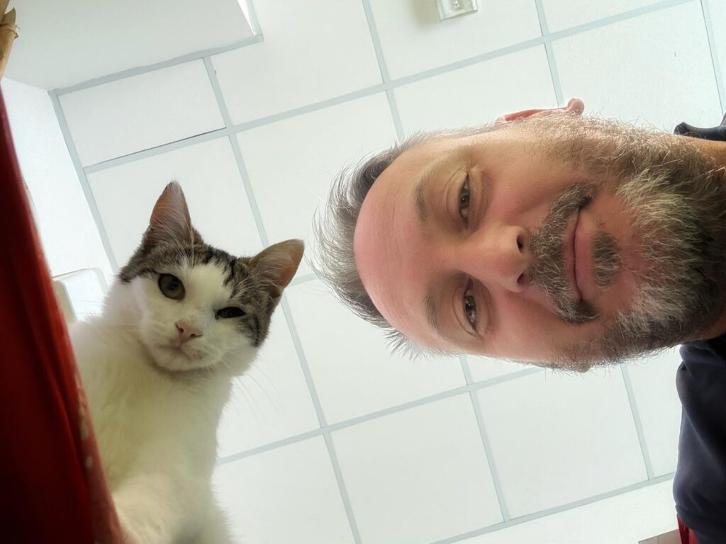 Il Dott. Colombo scatta una foto da sotto riprendendo lui e un gatto bianco che fa capolino